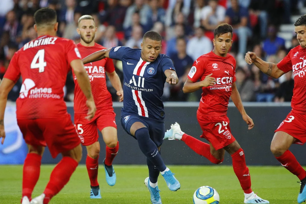 Kylian Mbappe đi bóng trước hàng thủ Nimes