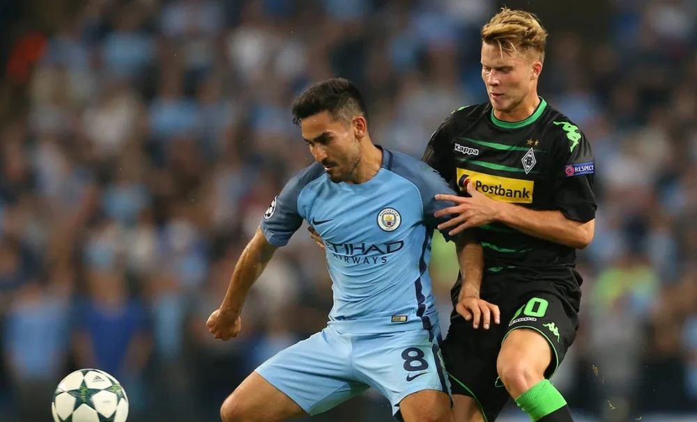 Ilkay Gundogan (trái, Manchester City) tranh bóng với Nico Elved (Borussia Mönchengladbach)