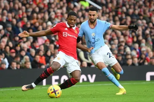 Riyad Mahrez (phải) bị chú nhóc Tyrell Malacia liên tục kéo ngã