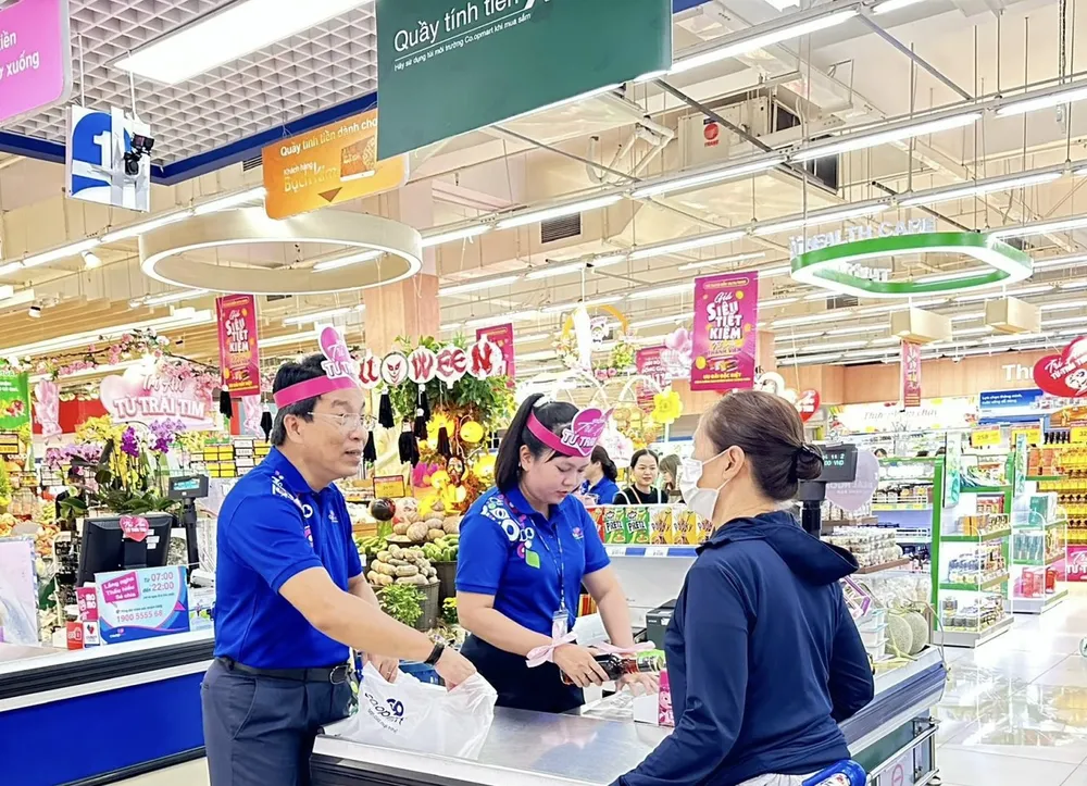 Ông Lê Trường Sơn, Phó Tổng Giám đốc Liên hiệp Hợp tác xã Thương mại TPHCM (Saigon Co.op) đang phục vụ khách hàng tại quầy tính tiền Co.opmart Huỳnh Tấn Phát