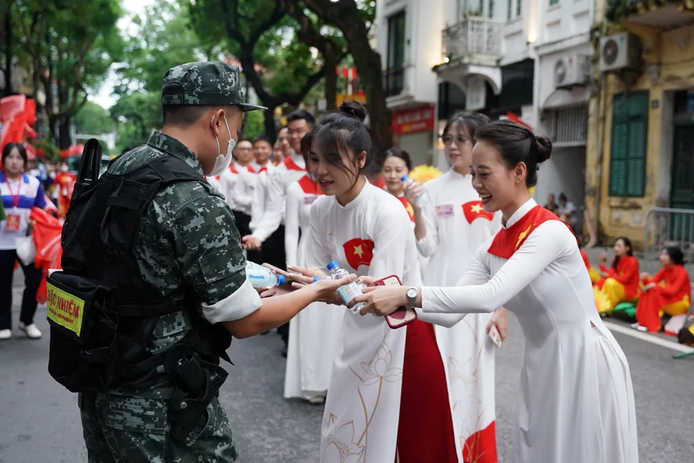 Nhiều người dân tiếp nước giữa giờ cho lực lượng làm nhiệm vụ. Ảnh: VI NAM ẢNH 06A.JPG