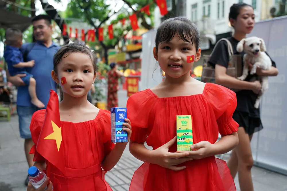 Em bé vui khoe hộp sữa Vinamilk vừa được nhận. Ảnh: VI NAM ẢNH 09B.JPG