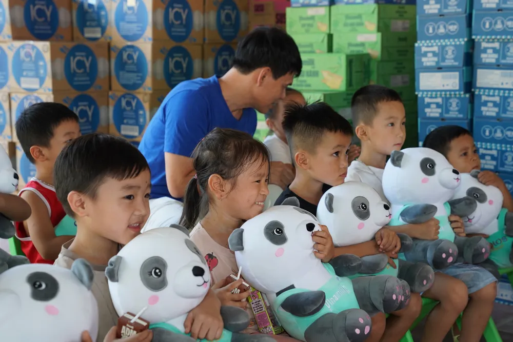 Nỗi sợ những ngày lũ dâng chưa tan, nhưng nụ cười đã hé lại khi các em được các cô chú Vinamilk đến tặng sữa, tặng quà. Ảnh: Tịnh Không ẢNH 05A.JPG