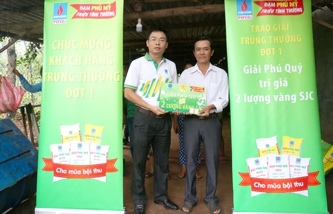 Đại diện PVFCCo trao thưởng và chia vui với khách hàng may mắn.