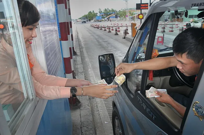 Nhân viên thu phí vẫn phải giữ thái độ hòa nhã mặc dù tài xế đưa những cọc tiền lẻ khi đến trạm Cai Lậy - Ảnh: THANH TÚ