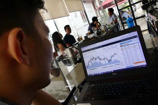 Một nhà đầu tư coin tại Q.3, TP.HCM theo dõi sàn giao dịch trên mạng