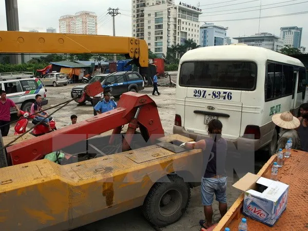 Di chuyển xe vi phạm tại một “bến cóc” ở khu vực gần bến xe Mỹ Đình. (Ảnh: Huy Hùng/TTXVN)