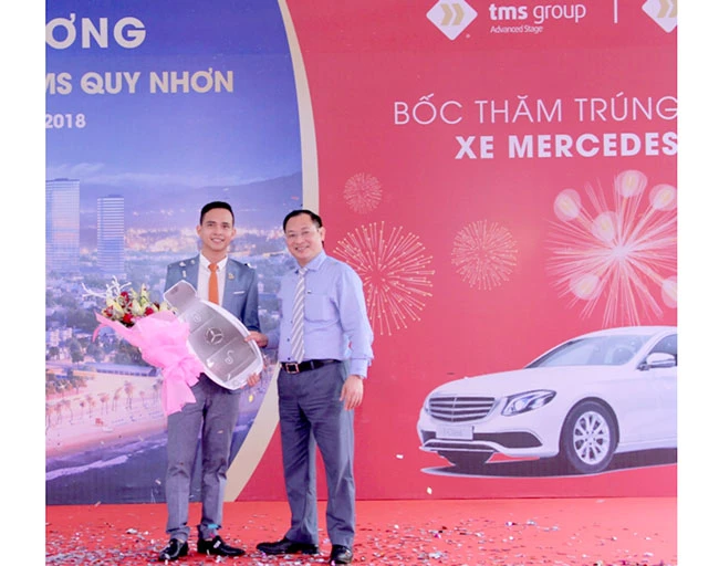 Tổng Giám đốc Nguyễn Việt Thung (bên phải) trao biểu trưng chìa khóa xe Merdeces E200 cho đại diện của bà Hoa 