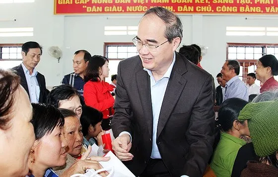 Bí thư Thành ủy TPHCM Nguyễn Thiện Nhân trao quà cho 100 người nghèo, nạn nhân da cam tại xã Nhơn Phong, Bình Định trong dịp đón Tết Mậu Tuất 2018. Ảnh: NGỌC OAI