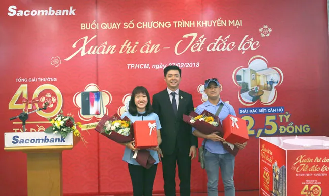 Ông Nguyễn Minh Tâm – Phó Tổng giám đốc Sacombank (giữa) trao giải bốc thăm may mắn cho các đại diện khách hàng tham dự buổi quay số.