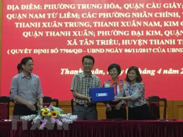 Đại diện Sở Quy hoạch - Kiến trúc Hà Nội bàn giao hồ sơ Đồ án thiết kế đô thị hai bên đường vành đai 3 cho các quận, huyện liên quan. (Ảnh: Mạnh Khánh/TTXVN)