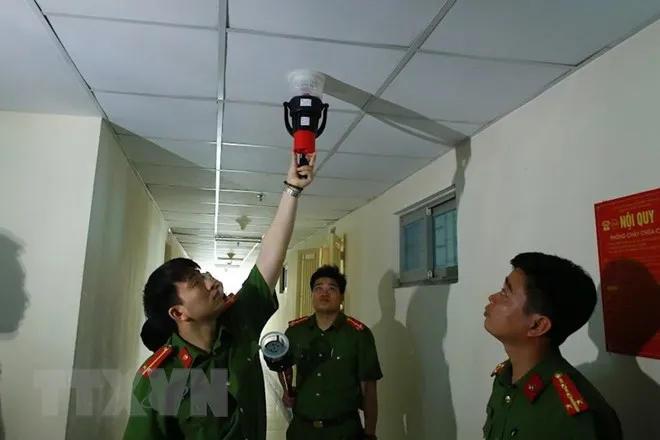 Cảnh sát phòng cháy, chữa cháy kiểm tra hệ thống báo cháy tại chung cư HH Linh Đàm. (Ảnh: TTXVN)