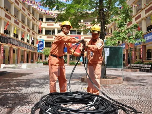 Công nhân điện lực Hà Nội kéo bổ sung nguồn dây cấp điện cho khu dân cư. (Ảnh Mạnh Khánh/TTXVN)