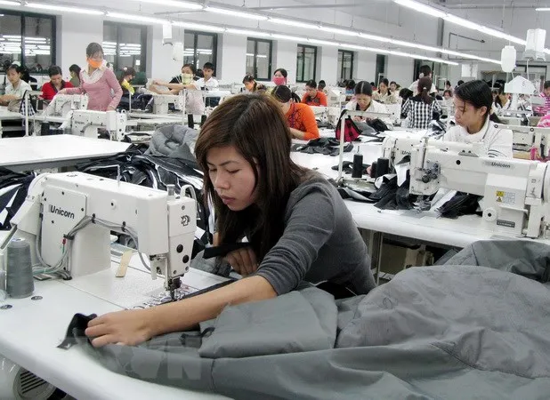 Công nhân sản xuất đồ may mặc. (Ảnh: Phạm Kiên/TTXVN)
