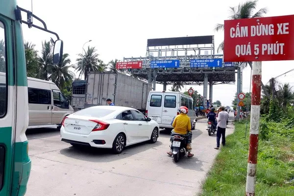Các phương tiện dừng xe tại trạm BOT T1 để phản ứng việc trạm chưa thực hiện giảm giá theo quy định. (Ảnh: Thanh Liêm/TTXVN)