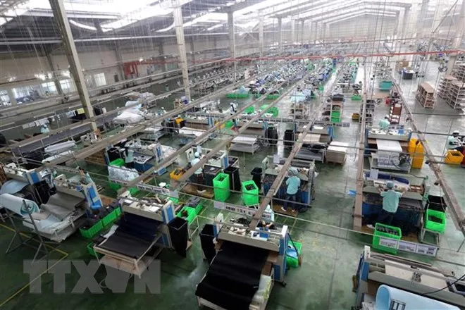 Dây chuyền sản xuất giày, dép xuất khẩu tại Công ty TNHH Midori Safety Footwear Việt Nam, vốn đầu tư của Nhật Bản tại khu công nghiệp Điện Nam-Điện Ngọc (Quảng Nam). (Ảnh: Danh Lam/TTXVN)