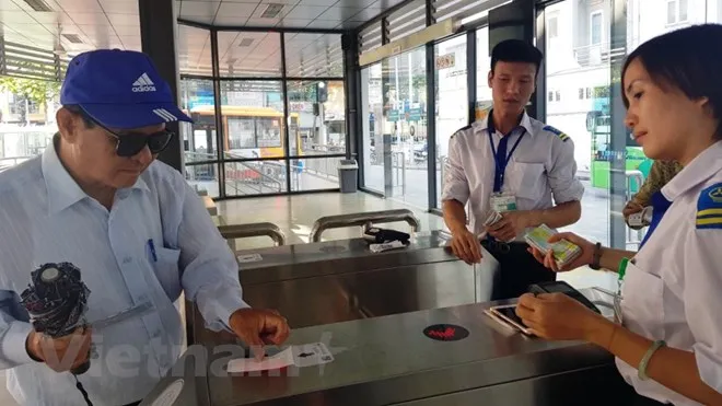 Khách sử dụng thẻ vé điện tử qua cổng kiểm soát để lên xe buýt nhanh BRT 01 Kim Mã-Yên Nghĩa. (Ảnh: Việt Hùng/Vietnam+)
