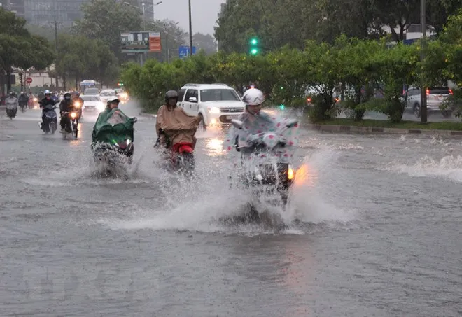 Các phương tiện lưu thông trong tình trạng ngập nước mỗi khi mưa lớn tại đường Nguyễn Hữu Cảnh, quận Bình Thạnh. (Ảnh: Xuân Dự/TTXVN)