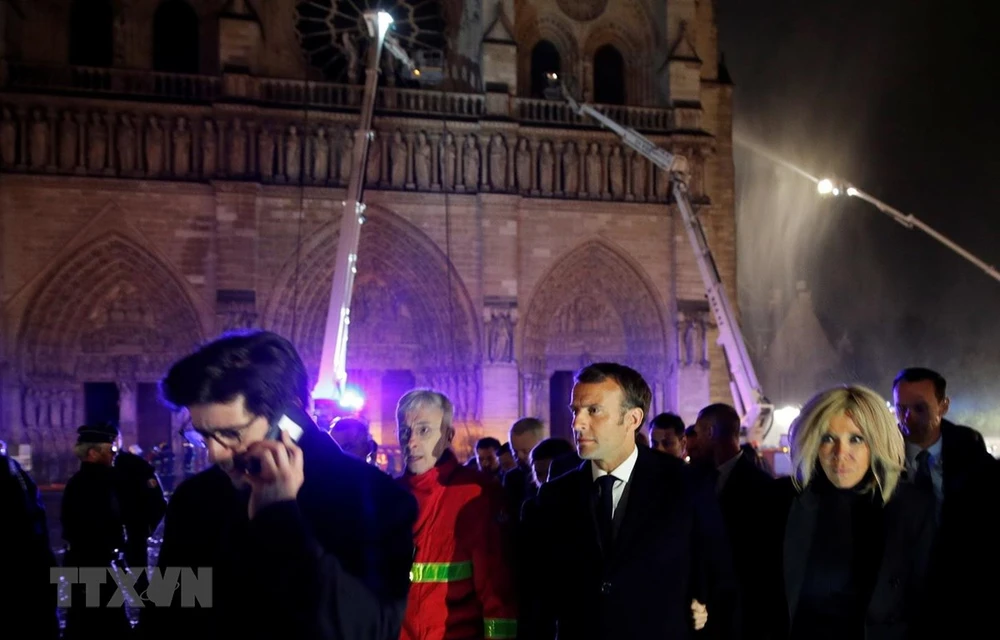 Tổng thống Pháp Emmanuel Macron cùng phu nhân thị sát hiện trường vụ cháy Nhà thờ Đức Bà ở Paris tối 15/4/2019. (Ảnh: AFP/TTXVN)