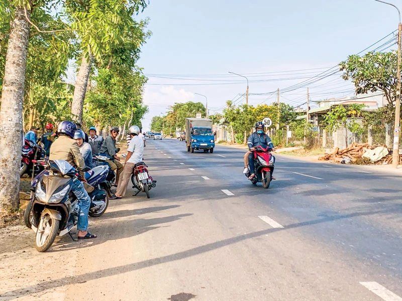 Cò đất tập trung hai bên Quốc lộ 56 chèo kéo khách đi đường. Ảnh: MINH TUẤN