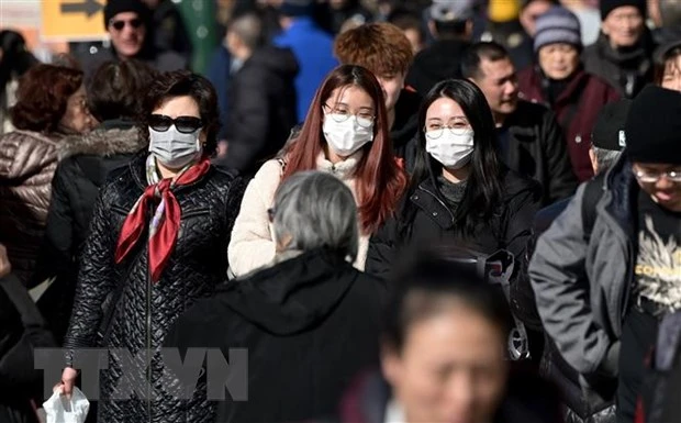 Người dân đeo khẩu trang để phòng tránh lây nhiễm COVID-19 tại New York, Mỹ. (Ảnh: AFP/TTXVN)