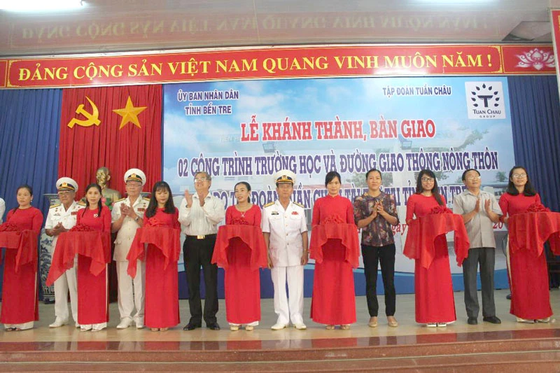 Đại diện chính quyền địa và nhà tài trợ cắt băng khánh thành các công trình trường học và đường giao thông nông thôn.