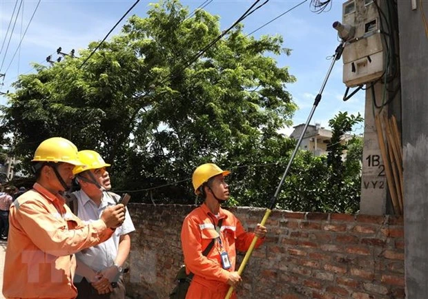 Kiểm tra quy trình ghi chỉ số công tơ tại Công ty Điện lực Mê Linh. (Ảnh: Ngọc Hà/TTXVN)