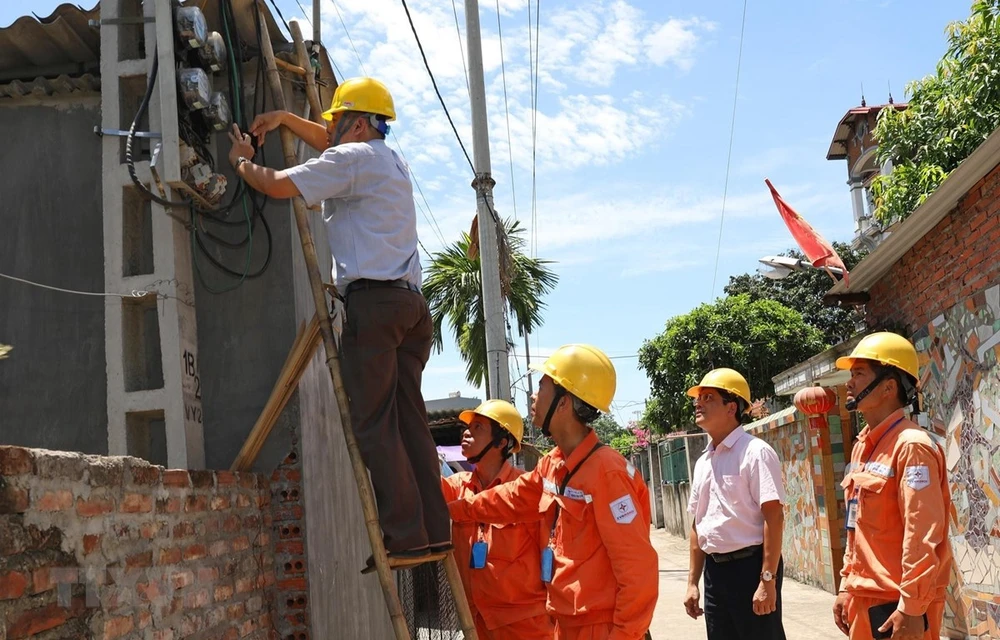 Đại diện Tổng cục Tiêu chuẩn Đo lường Chất lượng kiểm tra chì niêm phong côngtơ khách hàng sử dụng điện tại Công ty Điện lực Mê Linh, Hà Nội .(Ảnh: Ngọc Hà/TTXVN)