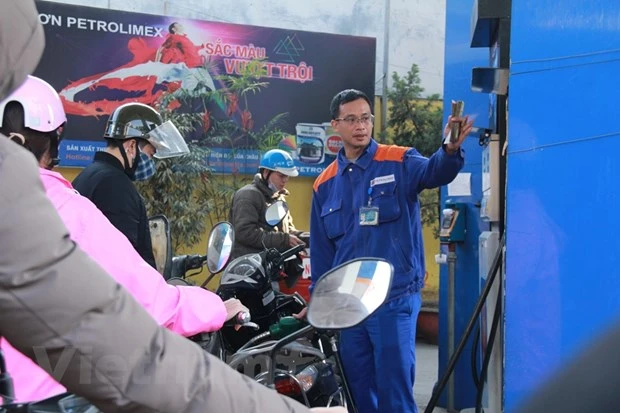 Nhân viên Petrolimex đang bán xăng cho khách hàng. (Ảnh: Đức Duy/Vietnam+)