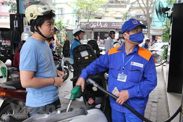 Nhân viên Petrolimex đang bán xăng cho khách hàng. (Ảnh: Đức Duy/Vietnam+)