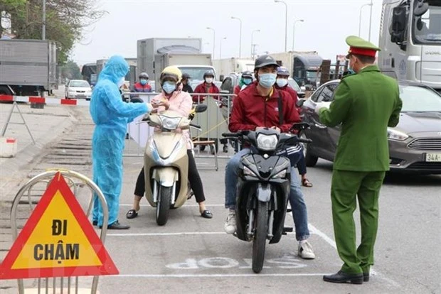 Lực lượng trực chốt kiểm soát cấp tỉnh tại ngã ba Hoàng Long, cửa ngõ phía tây thành phố Hải Dương kiểm tra kỹ giấy tờ của người dân lưu thông qua đây. (Ảnh: Mạnh Minh/TTXVN)