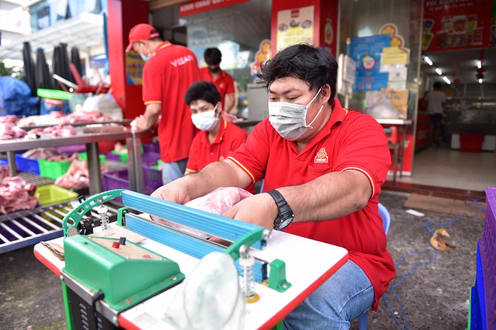 Nhân viên siêu thị Vissan trên đường Vũ Tùng, quận Bình Thạnh, pha lóc, đóng vỉ thịt heo - Ảnh: NGỌC PHƯỢNG