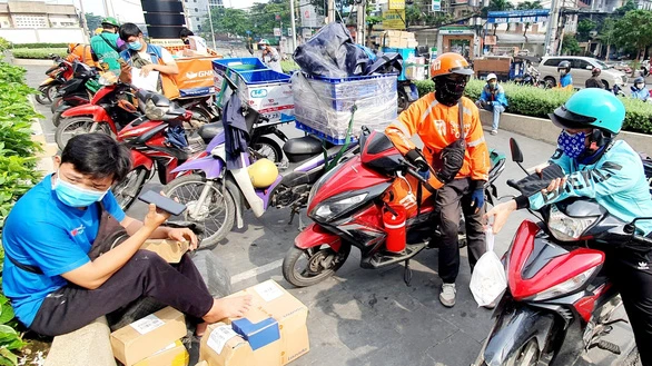 Các tài xế xe công nghệ tất bật ngày Tết giao hàng và chở khách - Ảnh: C.TRUNG