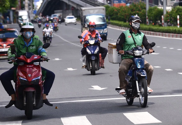 Grab, Gojek thu phụ phí 10.000 - 15.000 đồng/chuyến xe ngày Tết - Ảnh: QUANG ĐỊNH