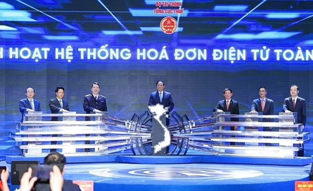 Thủ tướng Phạm Minh Chính và lãnh đạo Bộ Tài chính và Tổng Cục thuế thực hiện nghi thức kích hoạt Hệ thống hóa đơn điện tử toàn quốc. (Ảnh: Dương Giang/TTXVN)