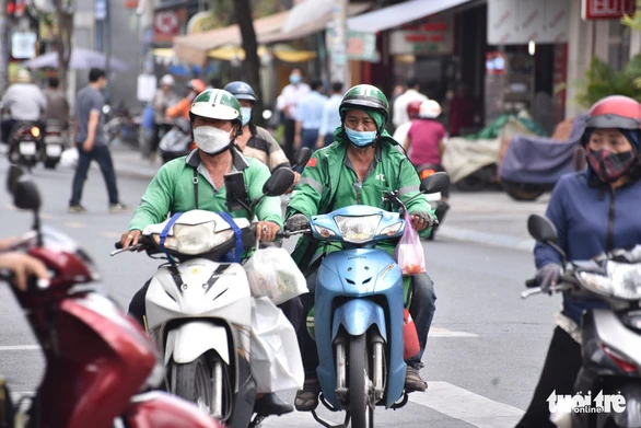 Tài xế xe công nghệ giao hàng ở đường Nguyễn Hữu Cầu, quận 1, TP.HCM - Ảnh: NGỌC PHƯỢNG