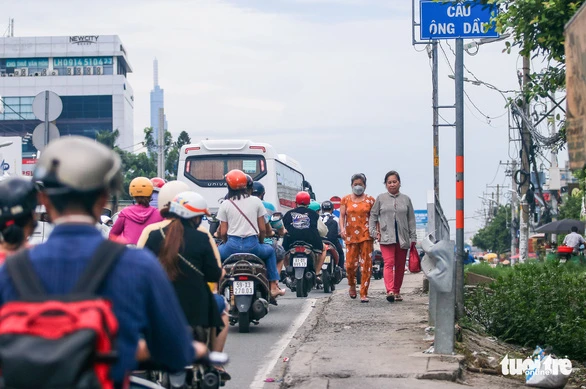 Mỗi khi ùn ứ giao thông, nhiều người dân phải luồn lách đi trên thành cầu - Ảnh: CHÂU TUẤN