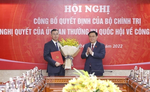 Chủ tịch Quốc hội Vương Đình Huệ trao Quyết định của Bộ Chính trị và tặng hoa ông Ngô Văn Tuấn. (Ảnh: Doãn Tấn/TTXVN)