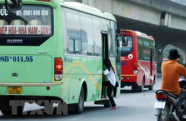 Xe khách dừng, đỗ đón trả khách sai quy định trên tuyến đường Phạm Hùng. (Ảnh: Phạm Kiên/TTXVN)