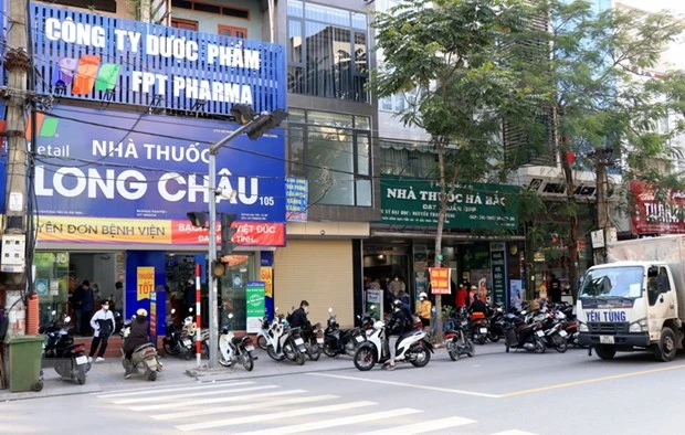 Người dân mua thuốc tại hiệu thuốc Long Châu. (Ảnh: Đinh Văn Nhiều/TTXVN)