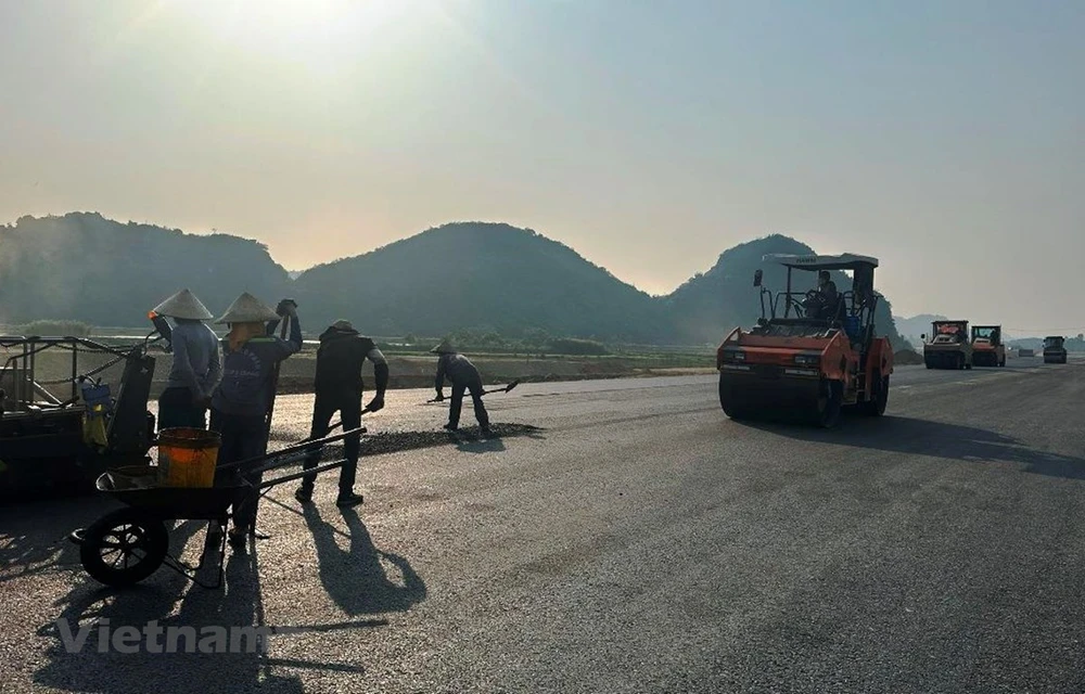 Nhà thầu thi công dải thảm lớp bê tông nhựa dự án cao tốc Bắc-Nam đoạn Mai Sơn-Quốc lộ 45 nhằm thông xe kỹ thuật vào ngày 31/12/2022. (Ảnh: Việt Hùng/Vietnam+)