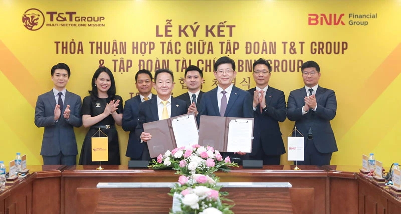 Ông Đỗ Quang Hiển, Chủ tịch UBCL Tập đoàn T&T Group (bên trái) và ông Bin Dae-in, Chủ tịch HĐQT kiêm TGĐ Tập đoàn Tài chính BNK (bên phải) trao thỏa thuận hợp tác với sự chứng kiến của đại diện lãnh đạo hai Tập đoàn.