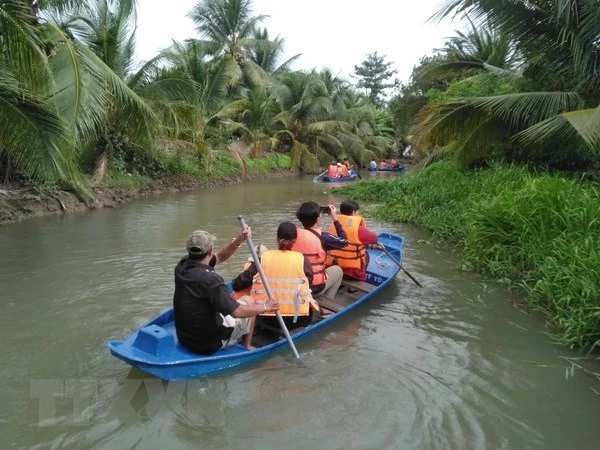 Du khách trải nghiệm hoạt động tự bơi xuồng trên sông trong Nông trại dê sữa du lịch Đông Nghi ở Tiền Giang. (Ảnh: Minh Hưng/TTXVN)