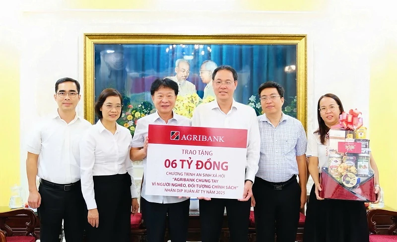 Ông Phạm Trung Kiên, Phó trưởng Văn phòng Đại diện Agribank khu vực miền Nam (bên trái) trao biển tượng trưng tặng kinh phí an sinh xã hội trên địa bàn TPHCM nhân dịp Tết Ất Tỵ 2025