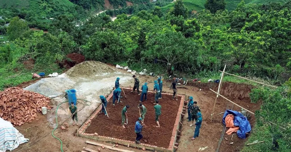 Các lực lượng tích cực tham gia xây dựng nhà ở cho nhân dân bị ảnh hưởng, thiệt hại do lũ quét, sạt lở đất trên địa bàn xã Huổi Một. (Ảnh: Quang Quyết/TTXVN) 
