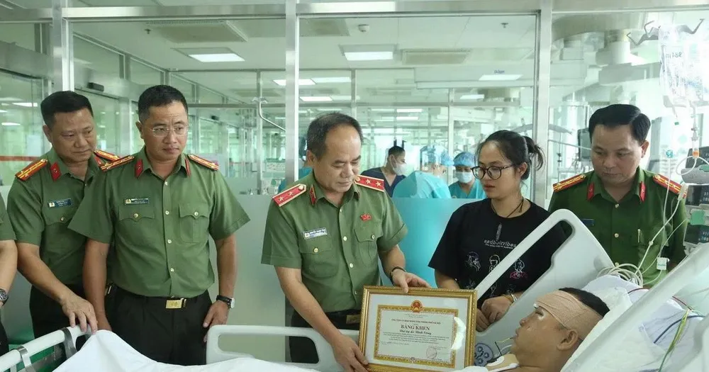 Trung tướng Nguyễn Thanh Tùng đã trao Bằng khen của Ủy ban Nhân dân thành phố cho Đại úy Lê Đình Công. (Nguồn: Tuổi trẻ Công an Thủ đô)