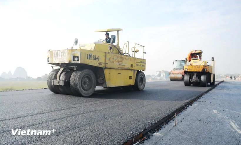 Nhà thầu thi công hạng mục thảm bêtông nhựa nền đường một tuyến cao tốc. (Ảnh: Việt Hùng/Vietnam+)