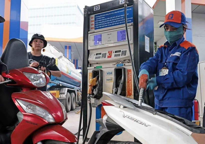 Khách hàng mua bán xăng, dầu tại một điểm kinh doanh xăng dầu của Petrolimex trên địa bàn Hà Nội. (Ảnh: Trần Việt /TTXVN) 