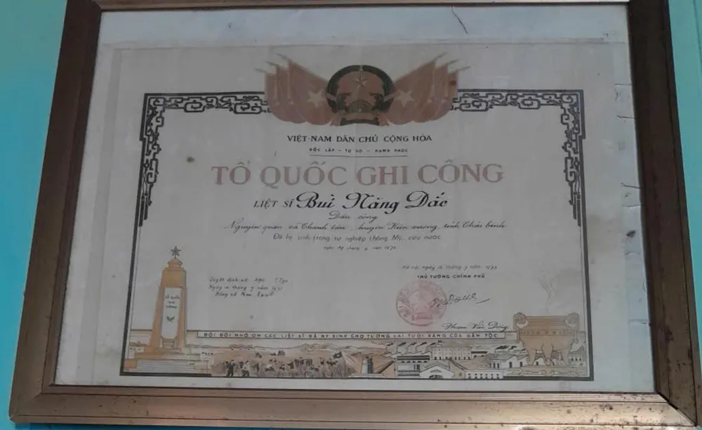 Tấm bằng Tổ quốc ghi công của liệt sĩ Bùi Năng Đắc được treo trang trọng tại quê nhà. (Ảnh: Gia đình cung cấp) LongDai14.jpg