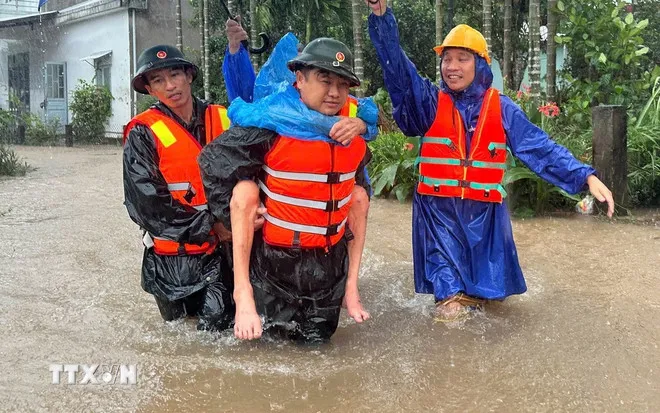 Lực lượng bộ đội và dân quân xã Duy Xuyên, thành phố Đà Nẵng giúp dân vùng lũ. (Ảnh: Trần Tĩnh/TTXVN)